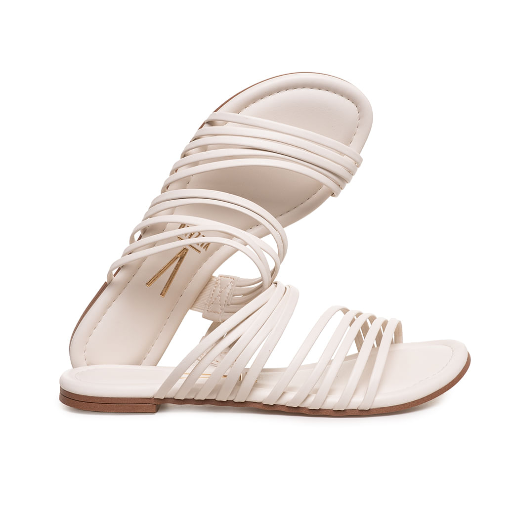 Perfil lateral da rasteira branca Vizzano com tiras finas e sola marrom